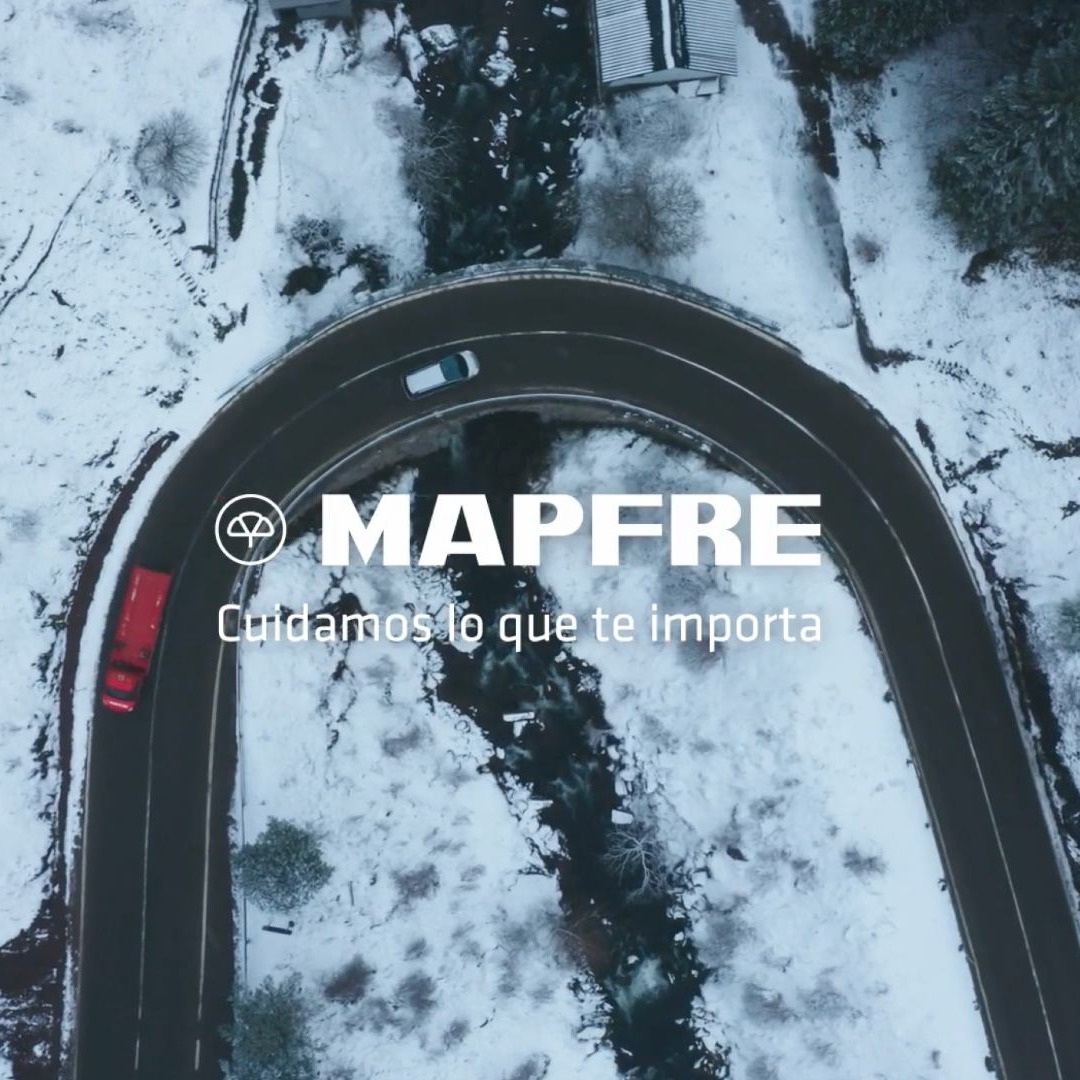 Plano cenital de una grúa de Mapfre en una carretera nevada