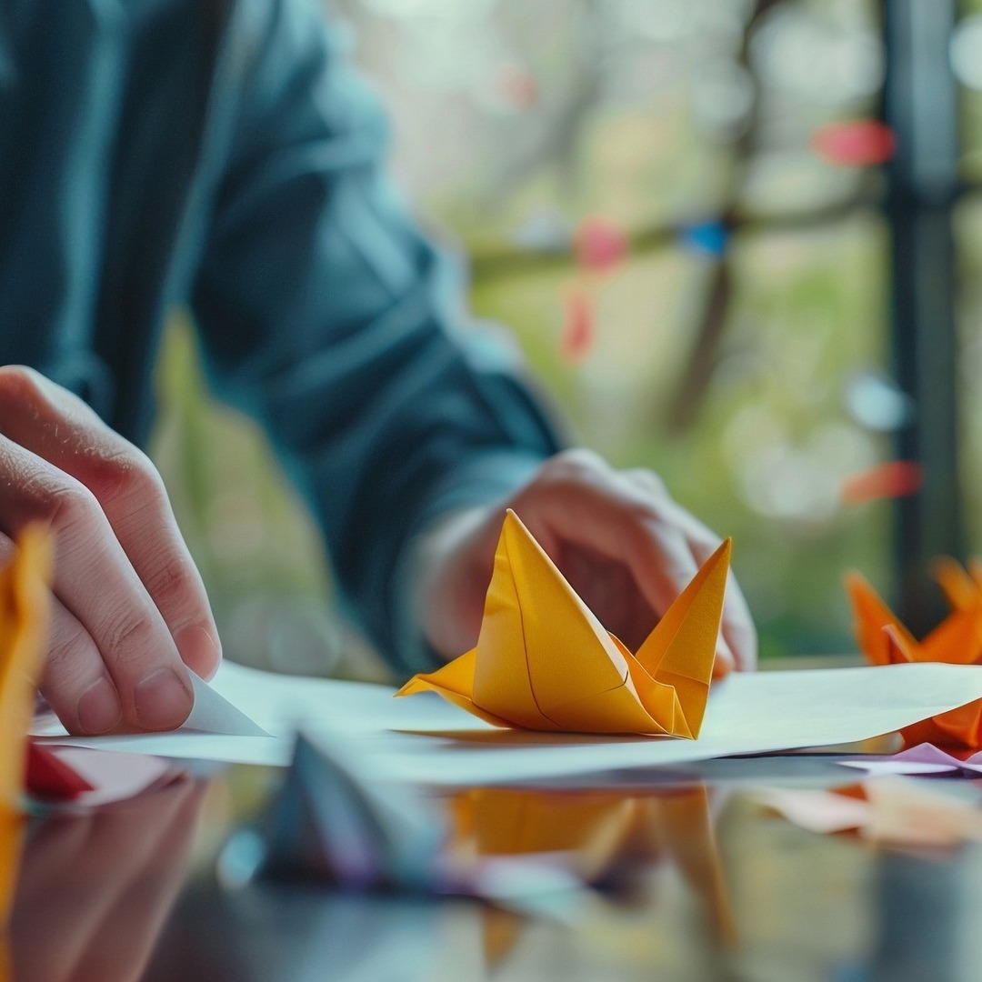 Persona haciendo origami en la oficina