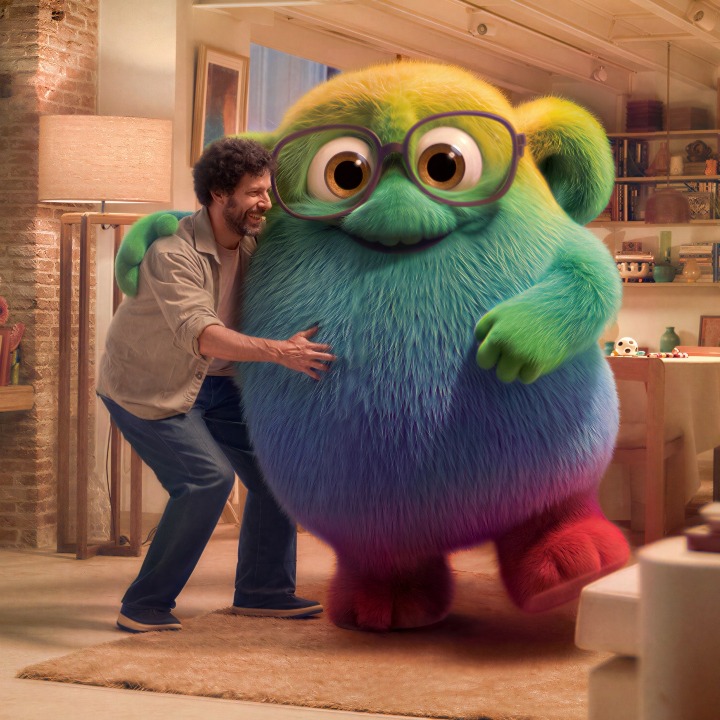 Un hombre abrazando a la mascota Totie en el salón