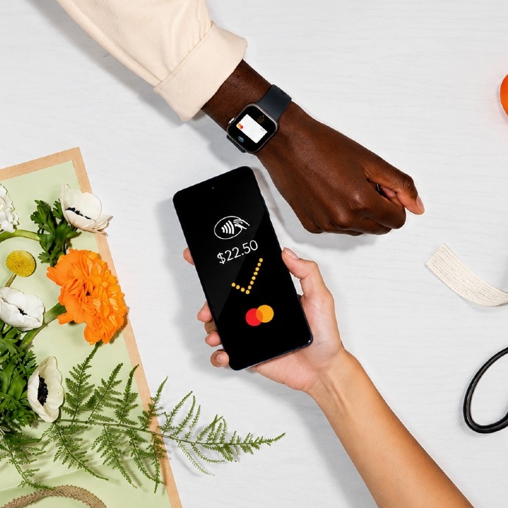 Una mano pagando con el teléfono a través de Mastercard