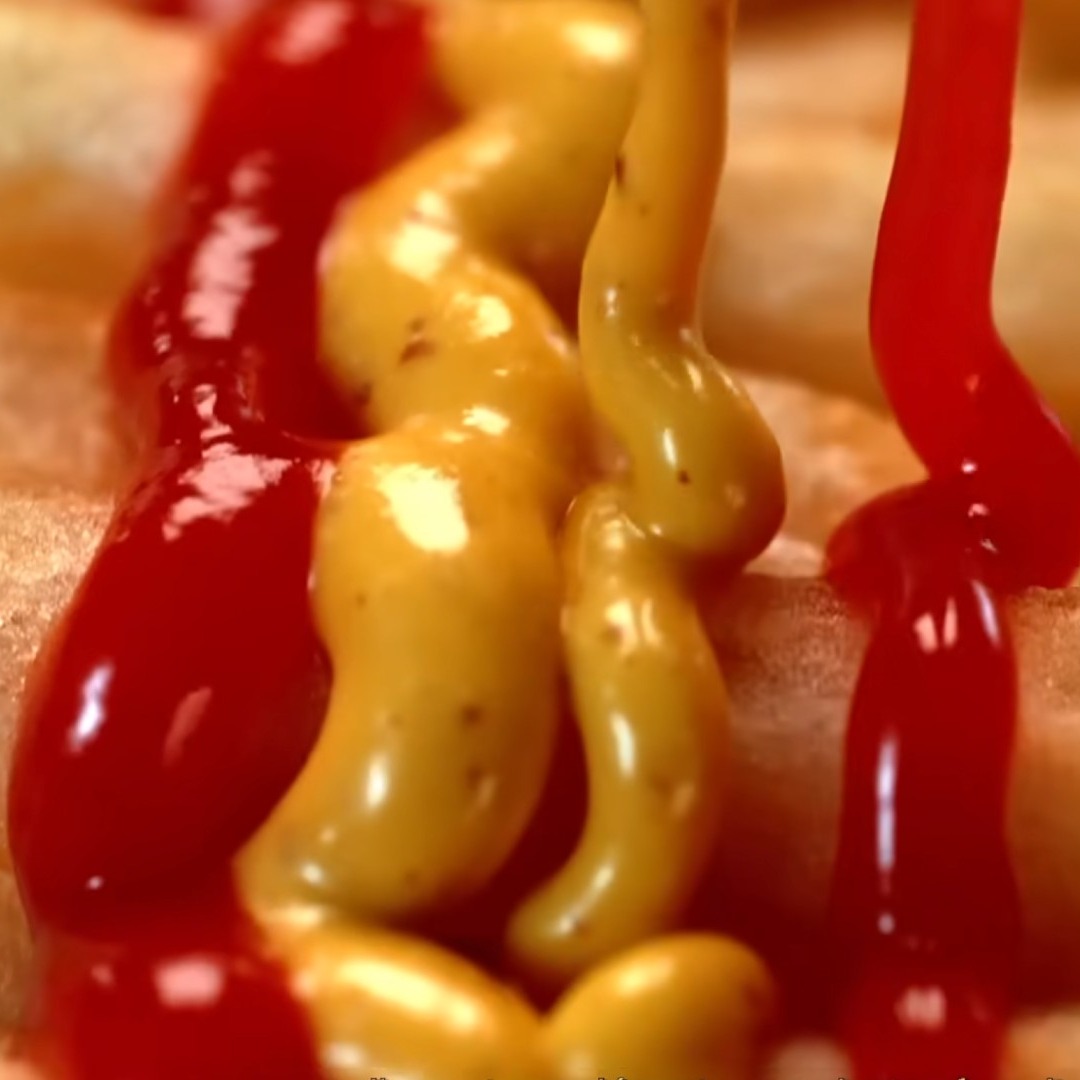 Mostaza y ketchup sobre patatas fritas formando bandera de España