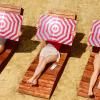 Mujeres sujetan un reflector invertido en la playa