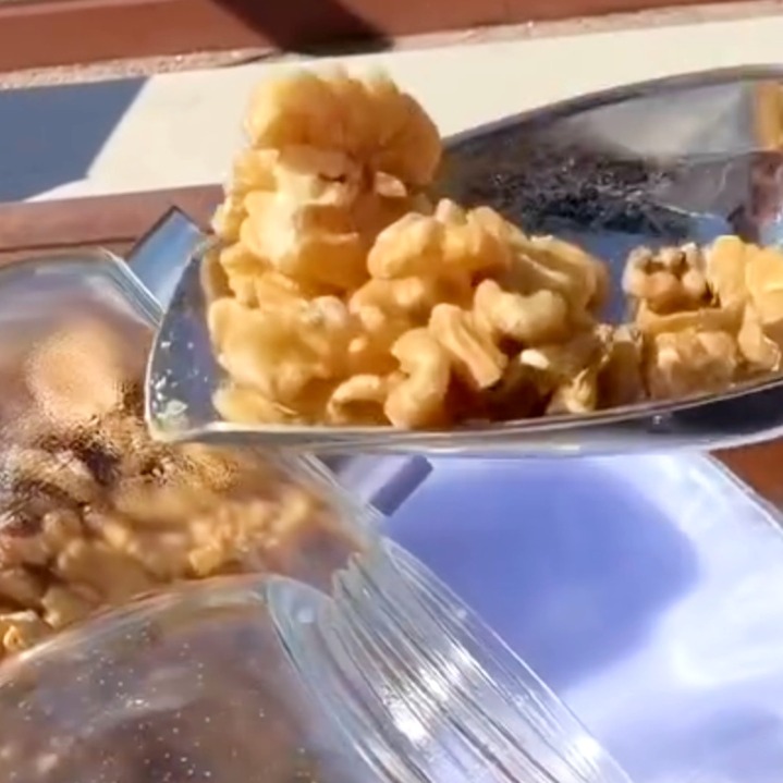 un cuenco con nueces peladas y al lado algunas en su cáscara