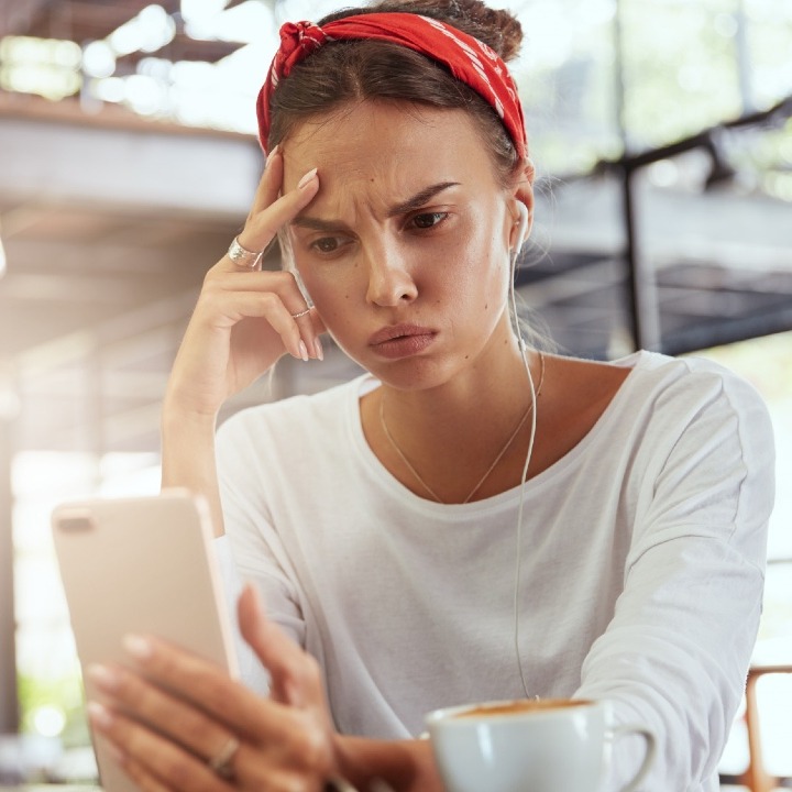 Una chica mira el teléfono con cara de preocupación
