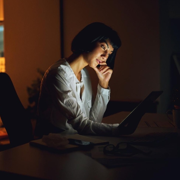 Una mujer trabajando en una oficina de noche