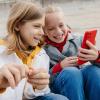 Dos niños mirando un smartphone sonriendo