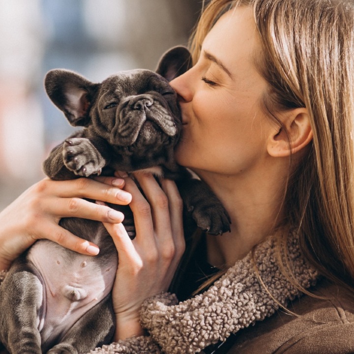 una chica abrazando y dando un beso a su perro