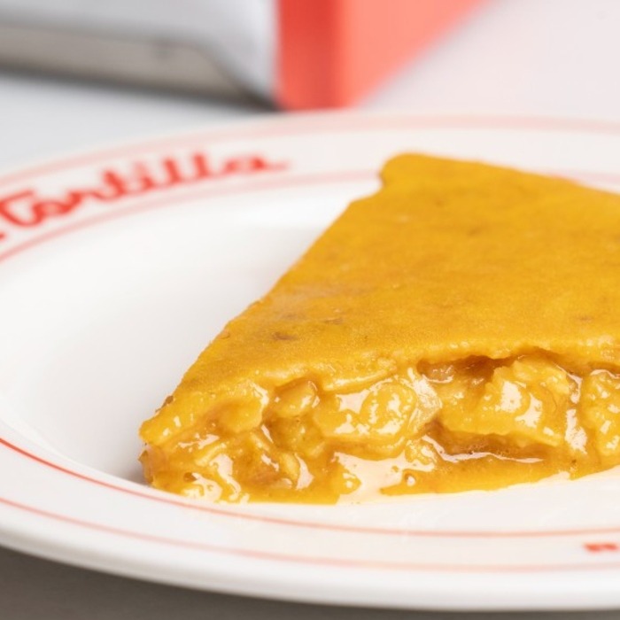 Un plato con un trozo de tortilla de patata