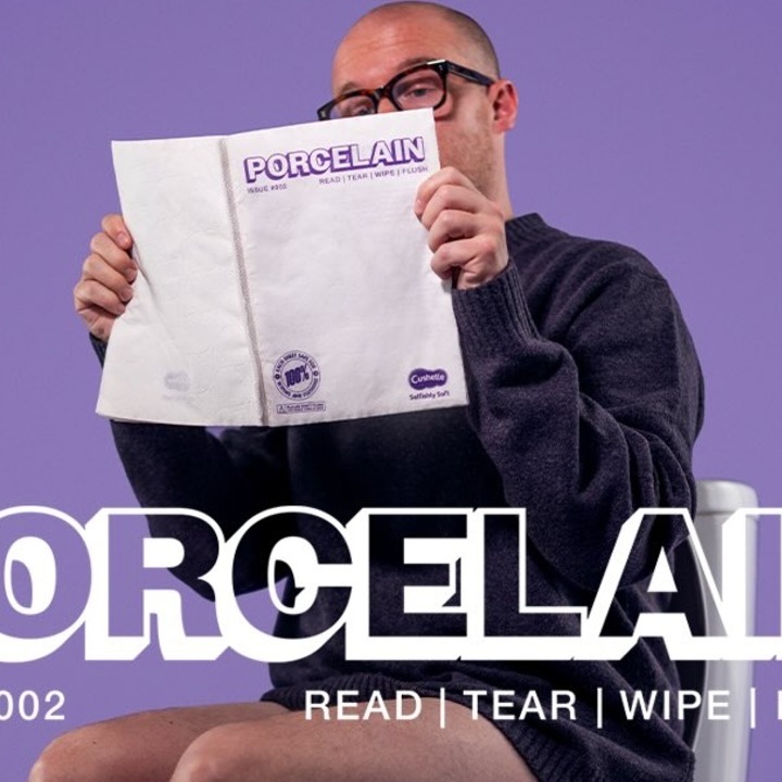 Un hombre sentado en el WC leyendo la revista