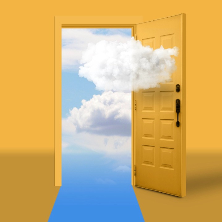 una puerta amarilla abierta a un cielo azul con nubes blancas