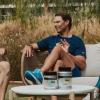 rafa nadal sentado charlando frente a una mesa con los suplementos alimenticios de su marca