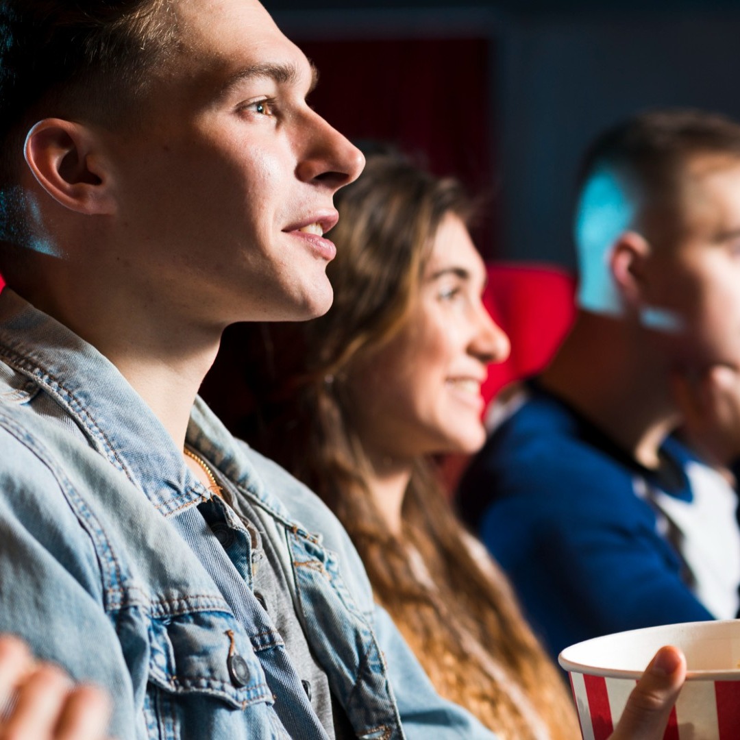 Gente joven viendo una película en el cine