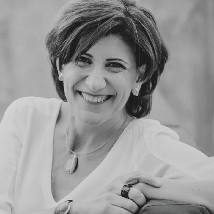 Foto en blanco y negro de Sara Blázquez sonriendo sentada en una butaca