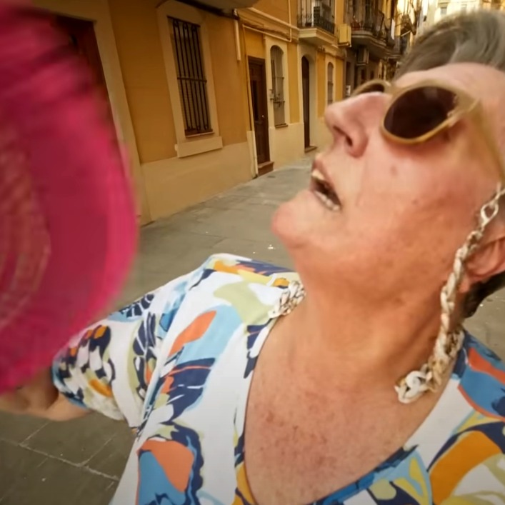 una señora abanicándose con expresión de calor