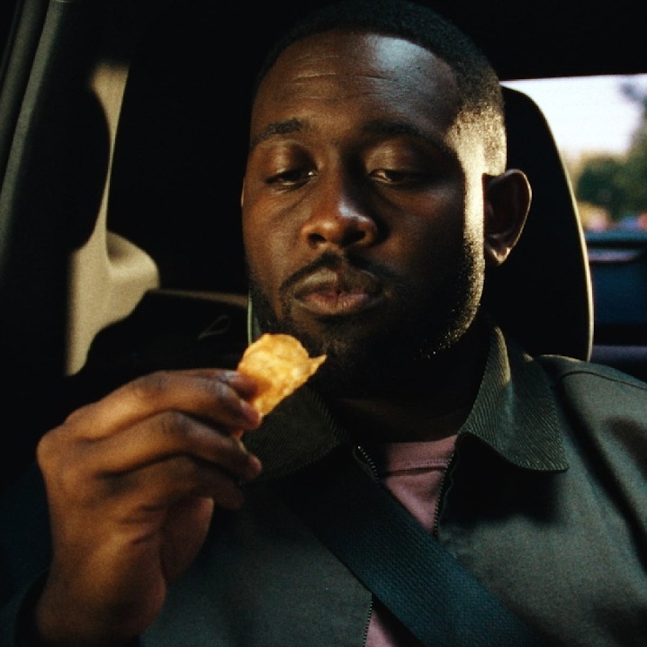 Un hombre a punto de comerse una patata crujiente en el coche