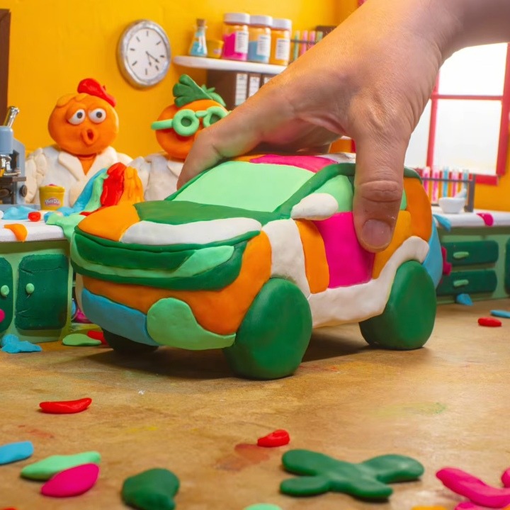 Una mano cogiendo un coche hecho con Play-Doh