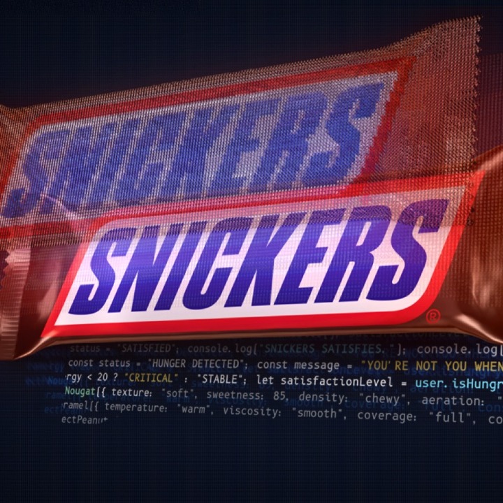 Una barra de chocolatina Snickers sobre un fondo de código de programación