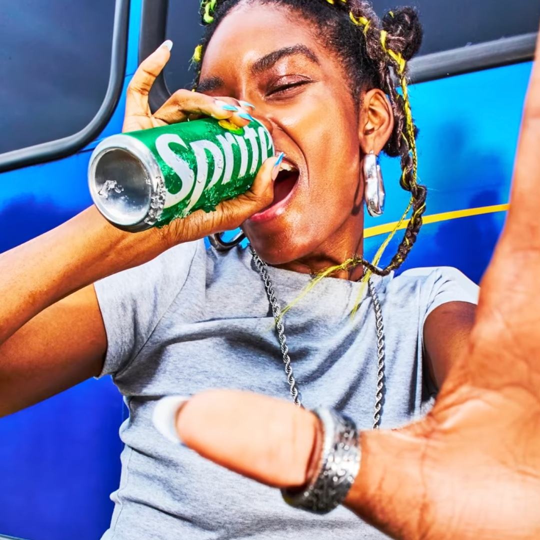 Chica bebiendo de una lata de Sprite