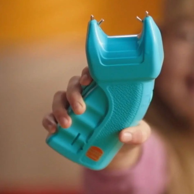 Una niña empuñando el taser azul de juguete