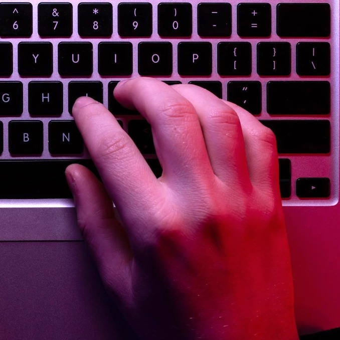 Una manos sobre el teclado de un ordenador portátil