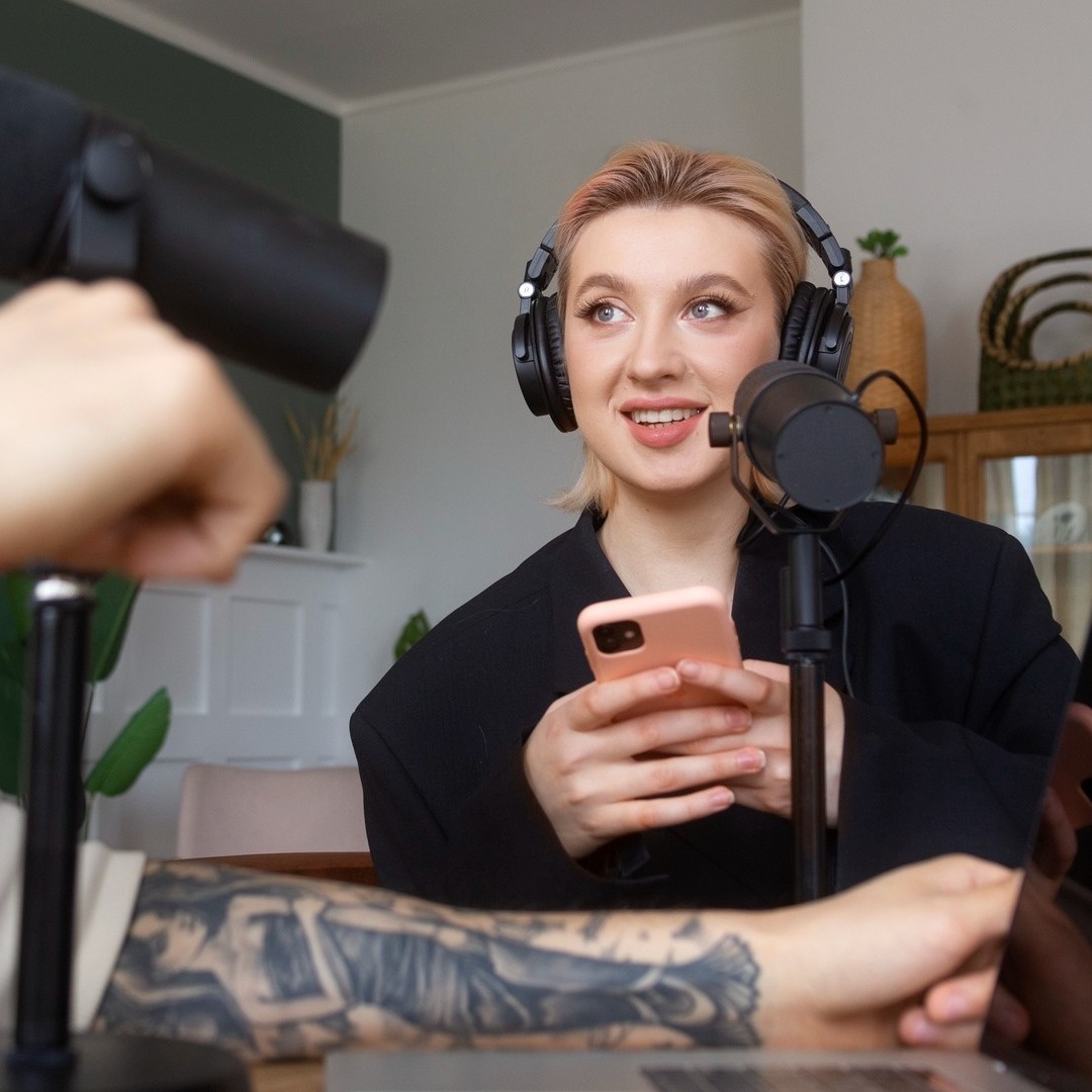 Una chica con el móvil en la mano mientras habla en un podcast
