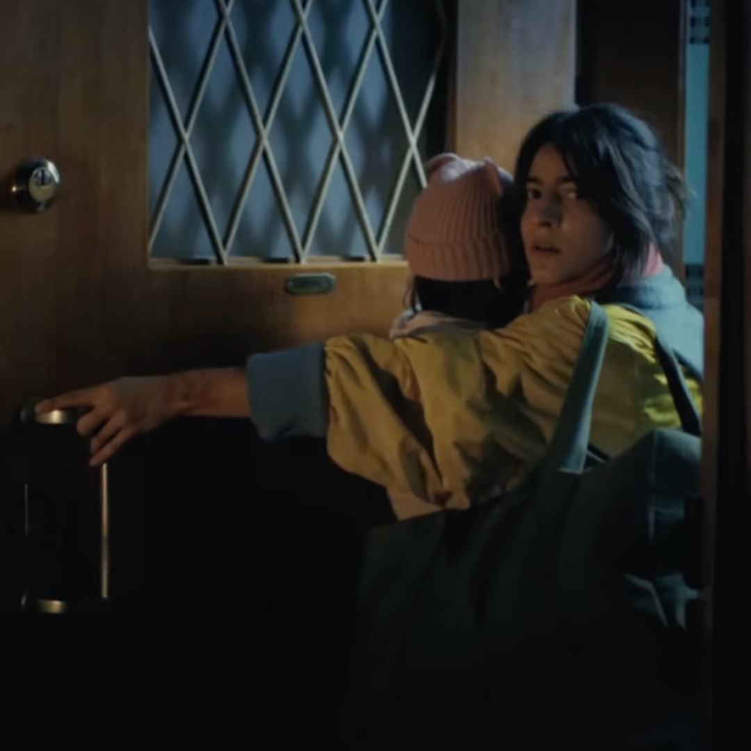 Mujer con un niño en brazos se va de casa