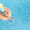 Mujer trabajando en verano sobre un flotador en la piscina