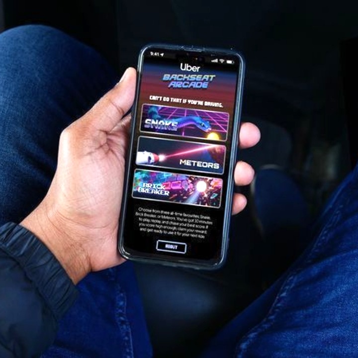 Un viajero sosteniendo el smartphone con la interfaz del juego de arcade