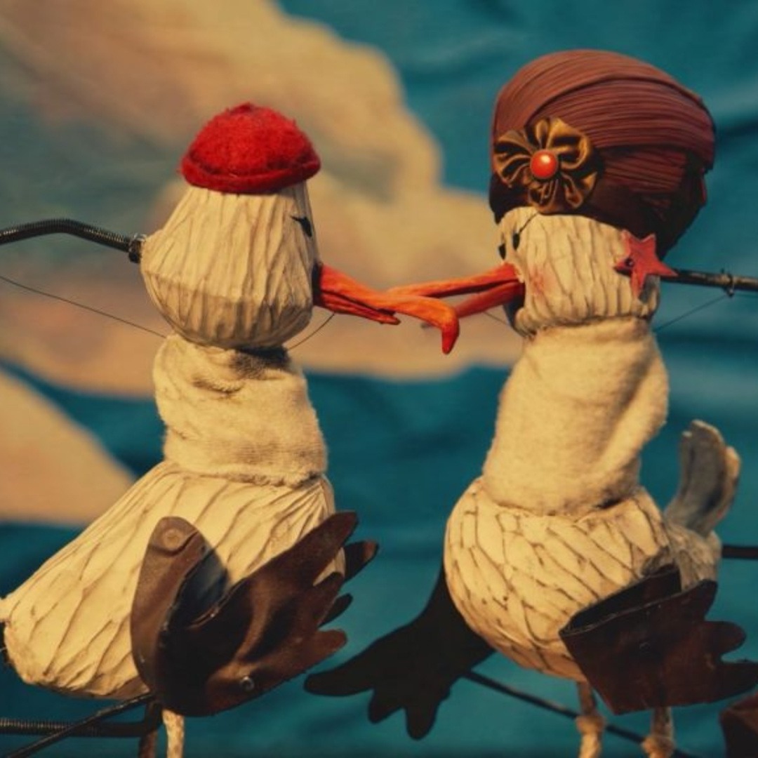 Dos albatros creados con marionetas mirándose entre sí antes de separarse.
