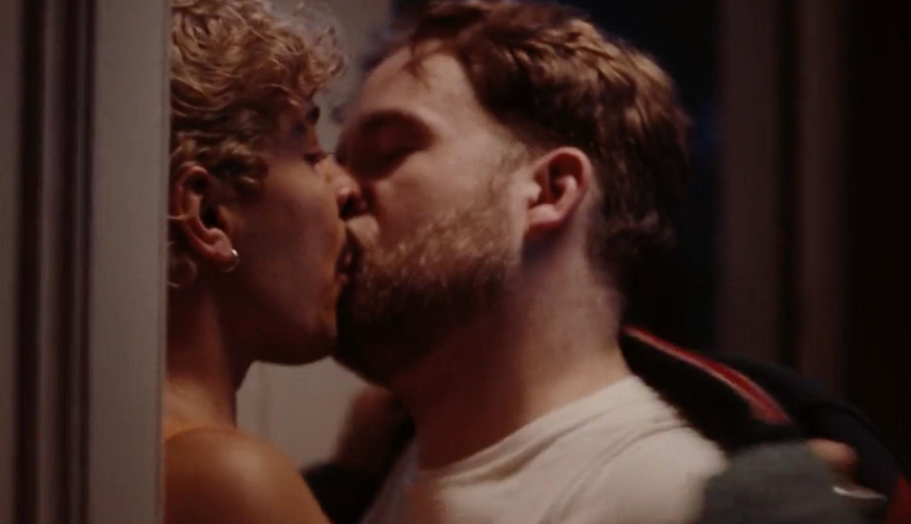 Dos hombres jóvenes besándose