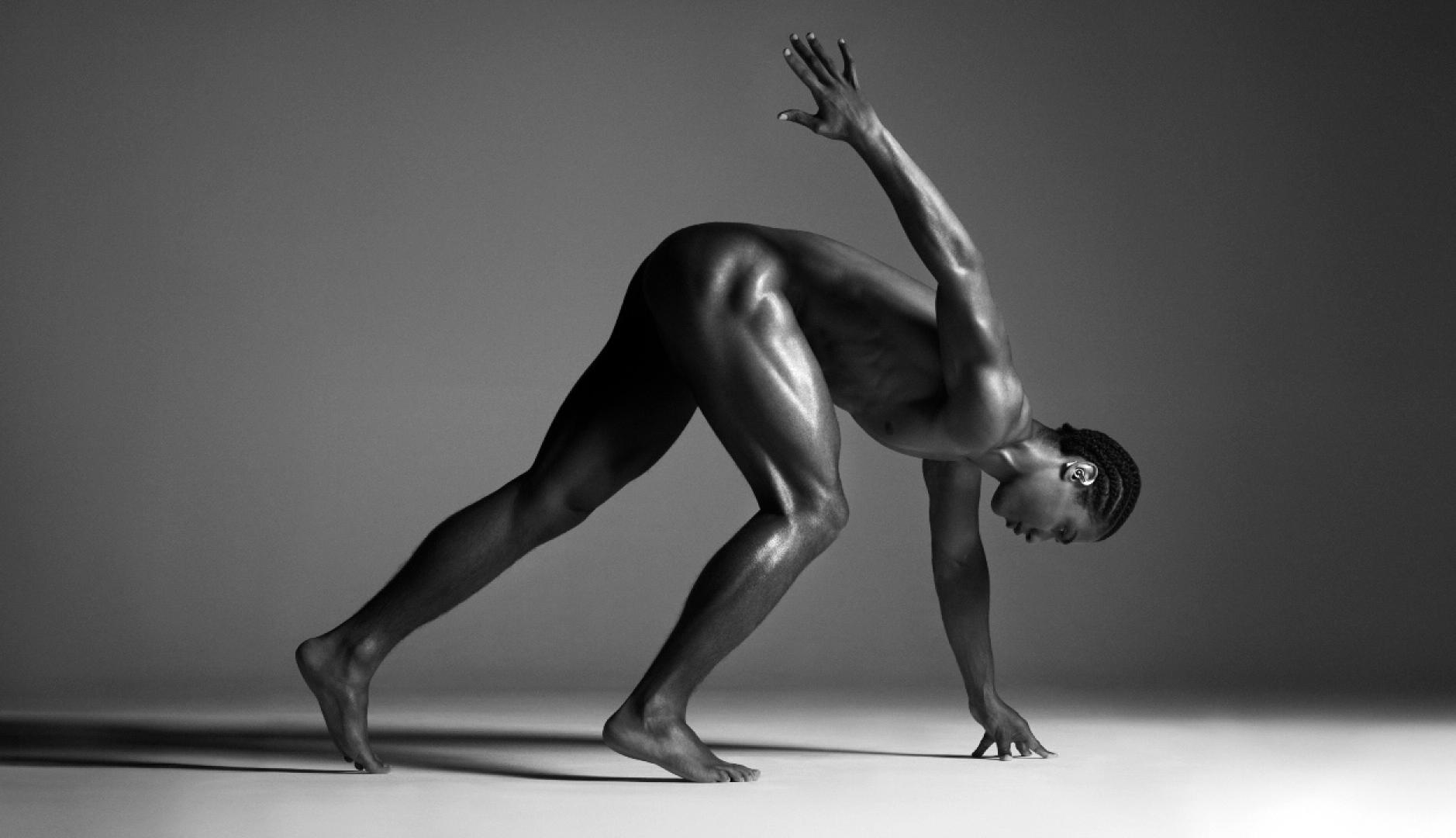 Un atleta negro desnudo como si fuera a salir a correr una carrera
