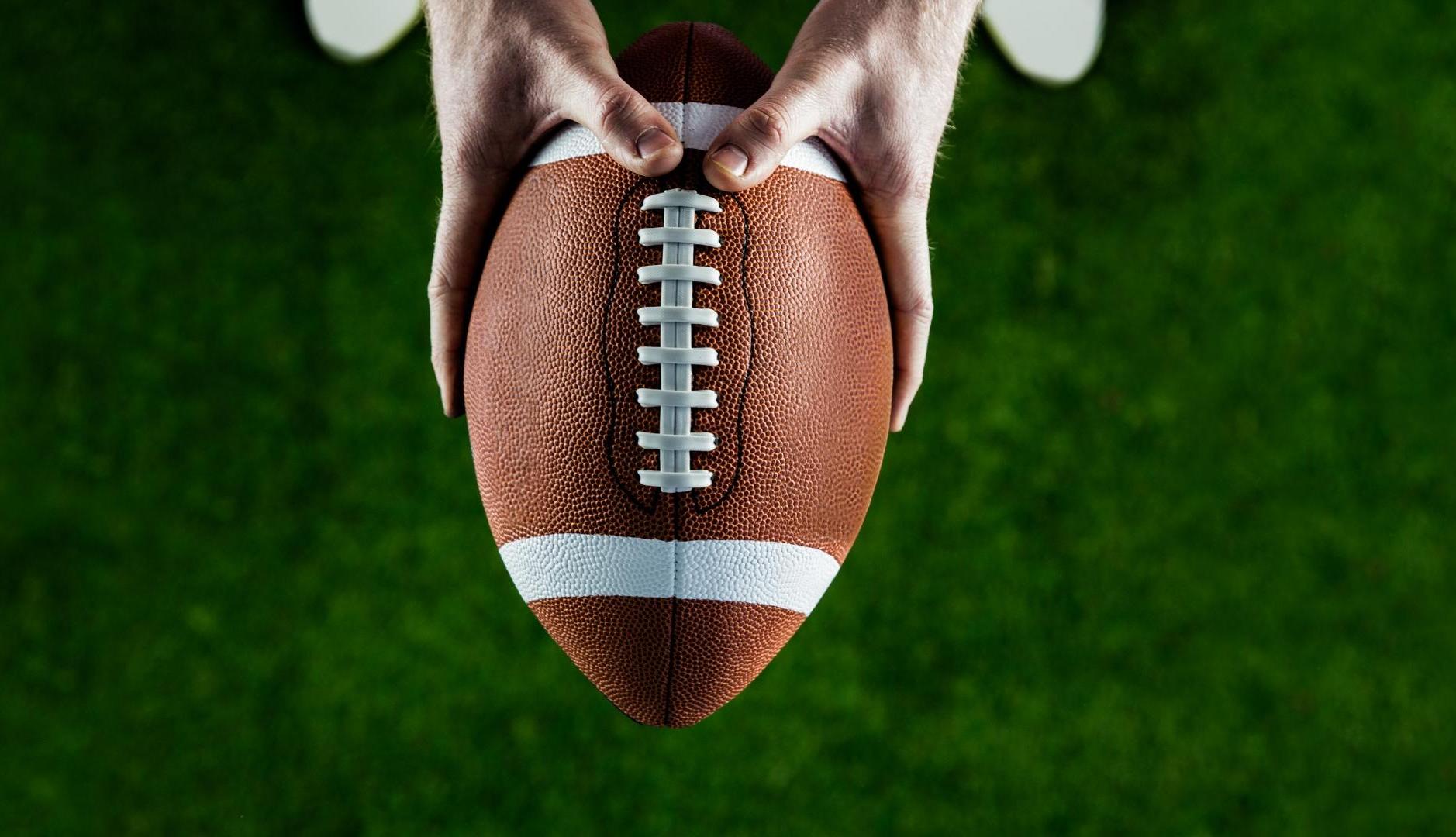 Manos sujetando un balón de rugby