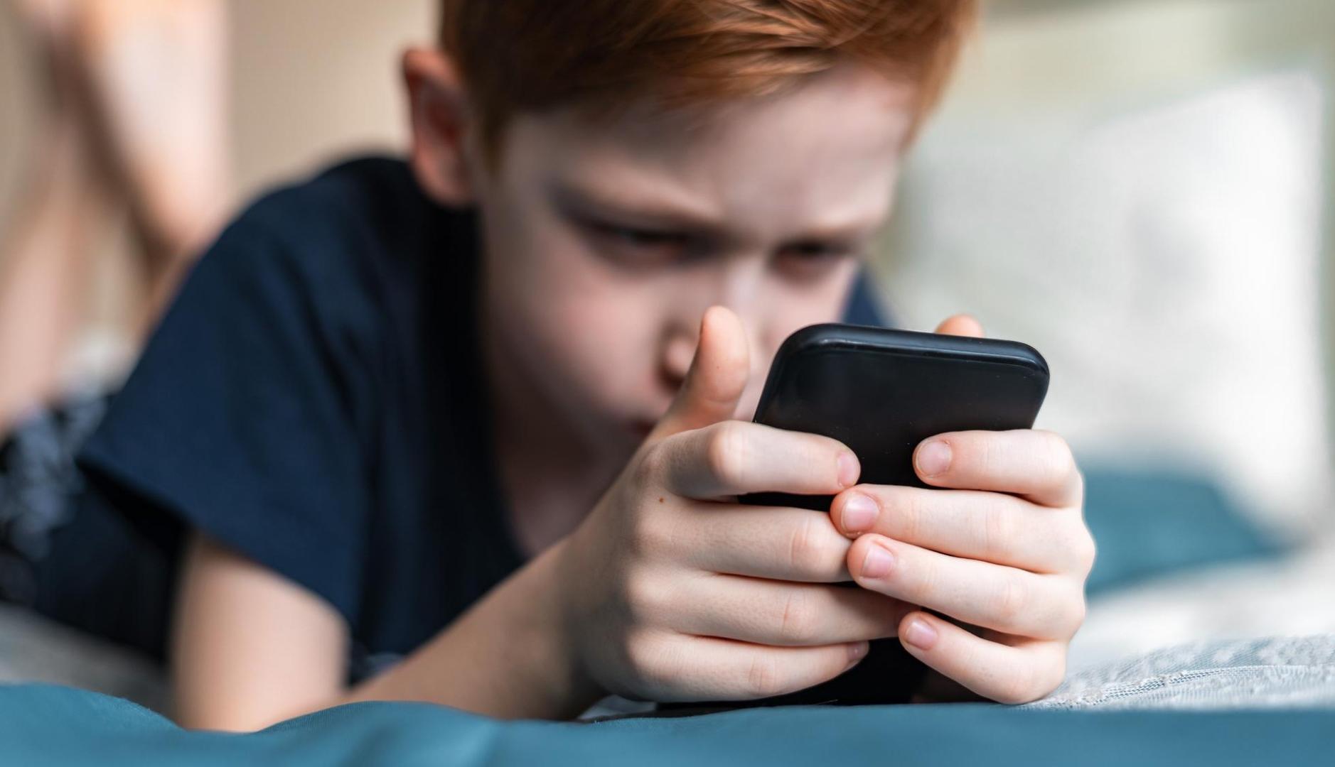 Niño mirando un teléfono móvil