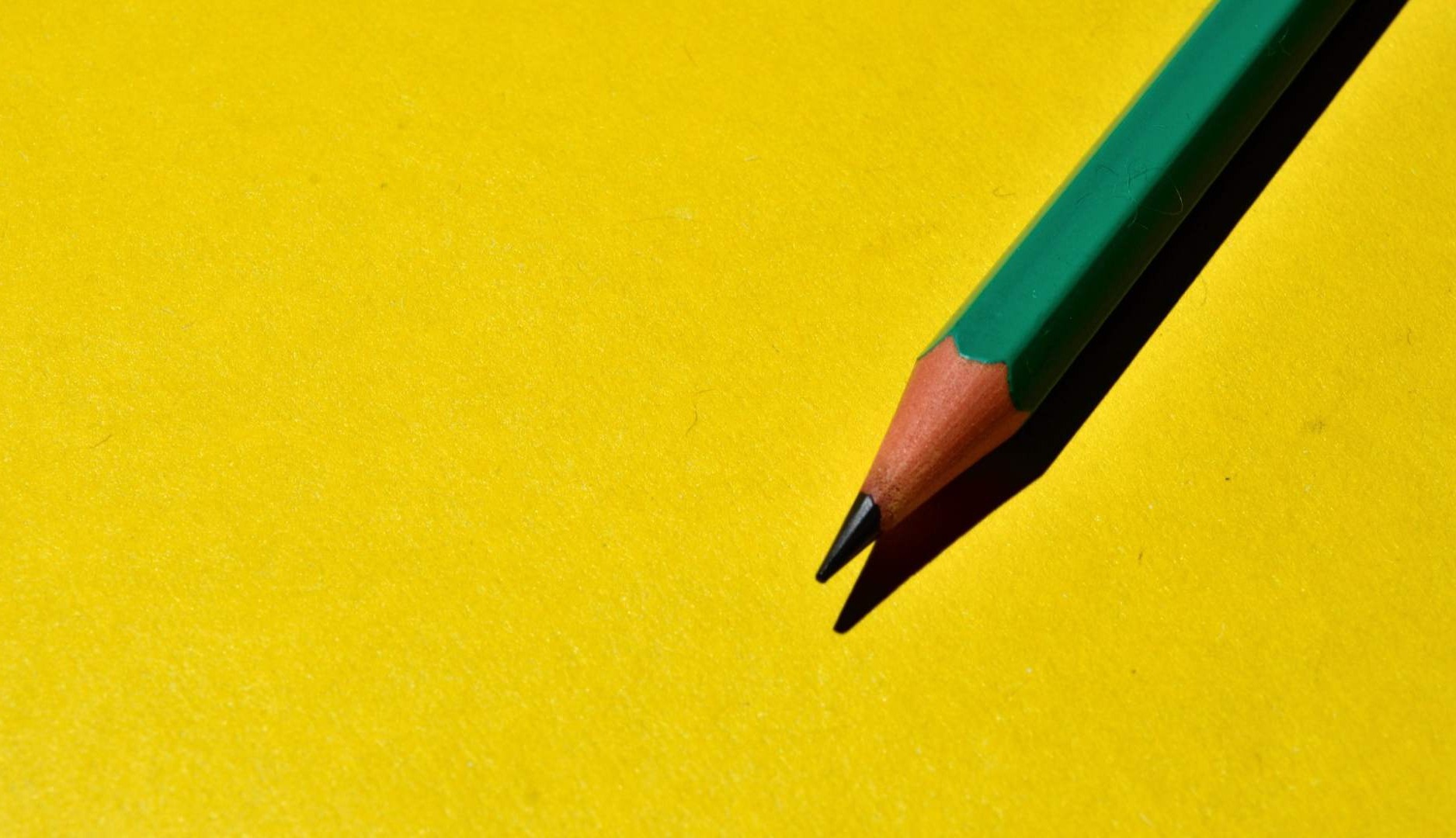 Lápiz verde sobre fondo amarillo