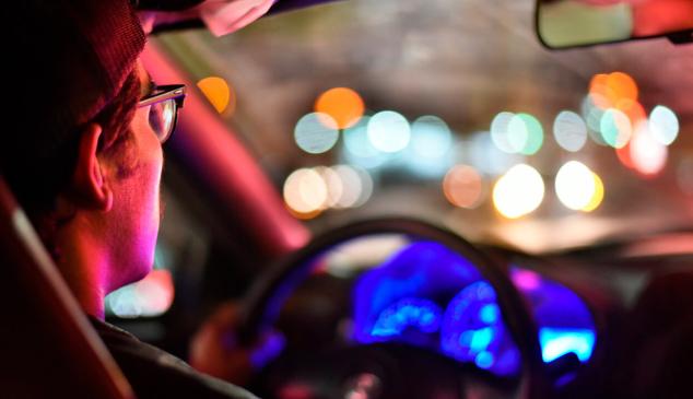 Hombre dentro de un coche con iluminación de colores