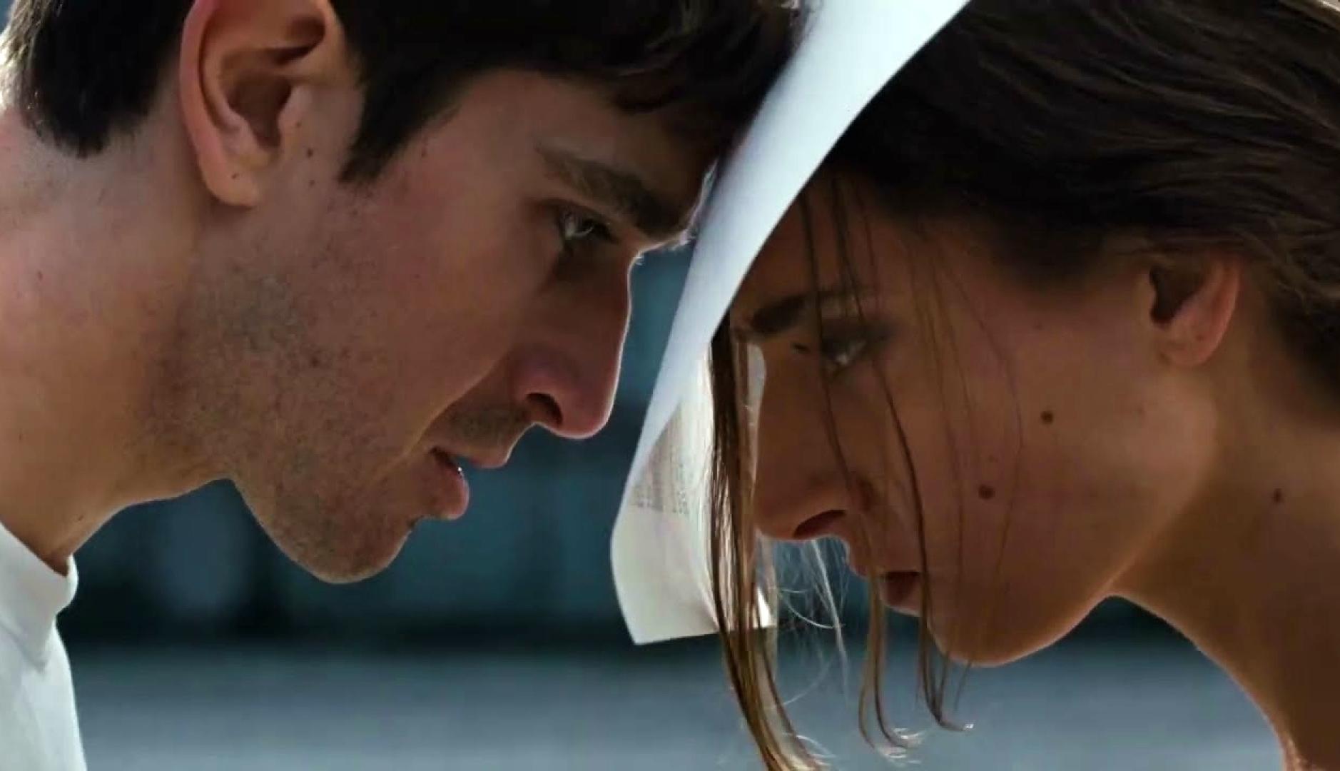 Un hombre y una mujer juntando la frente con un folio de papel entre ambos