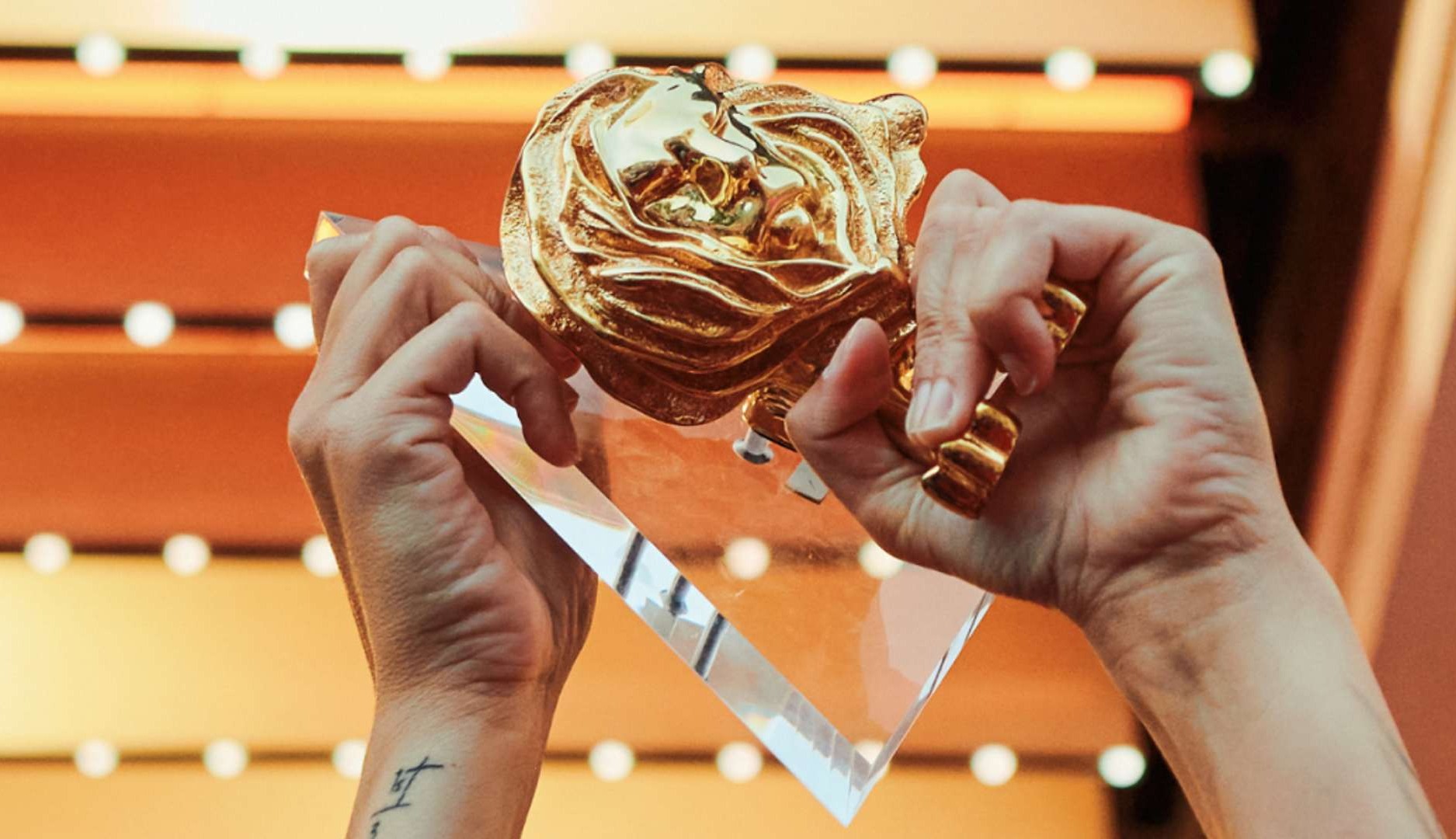 Manos sujetando trofeo de Cannes Lions