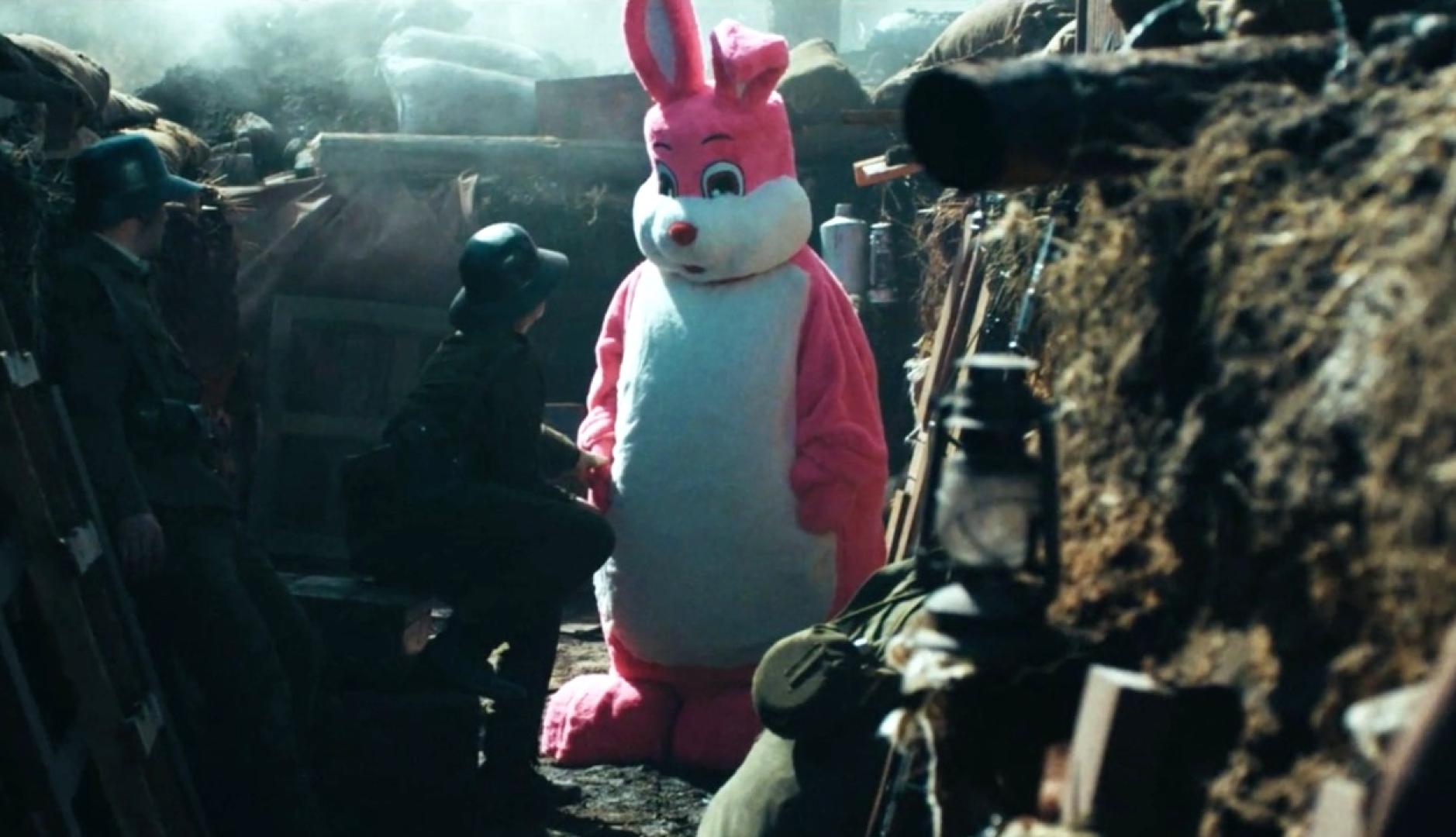 Un conejo rosa, como el de Duracell, en una trinchera bélica con soldados y armas