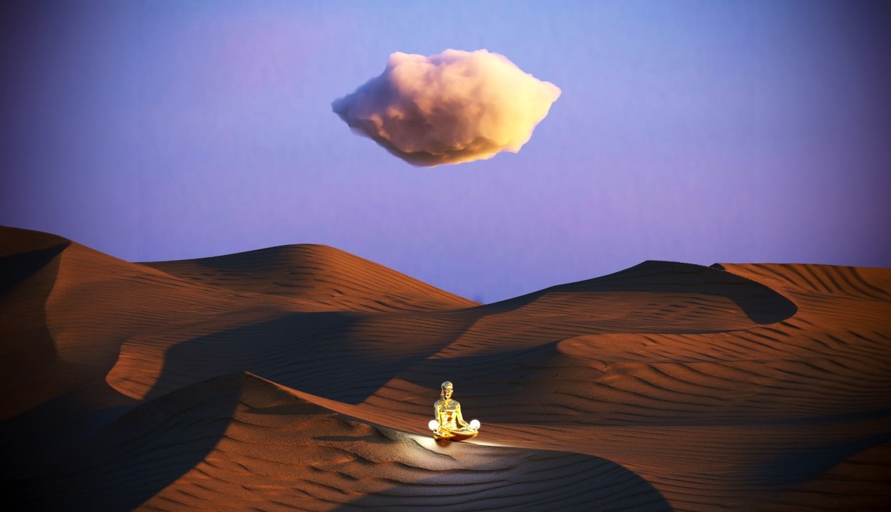 Estatua de una persona meditando en el desierto con una nube sobre su cabeza