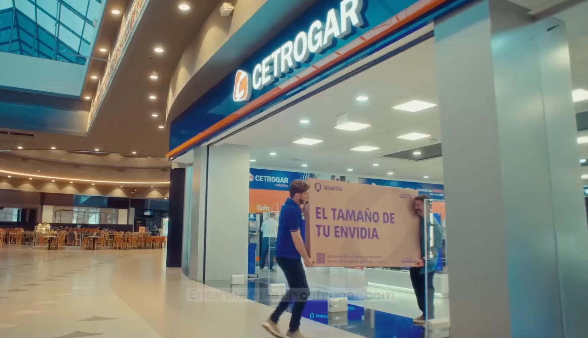 Dos personas sujetan la caja de un televisor saliendo de una tienda de Cetrogar