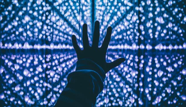 Mano sobre luces en tonos azules para representar el uso de los datos personales
