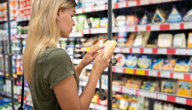 Mujer mira atentamente un producto en un supermercado