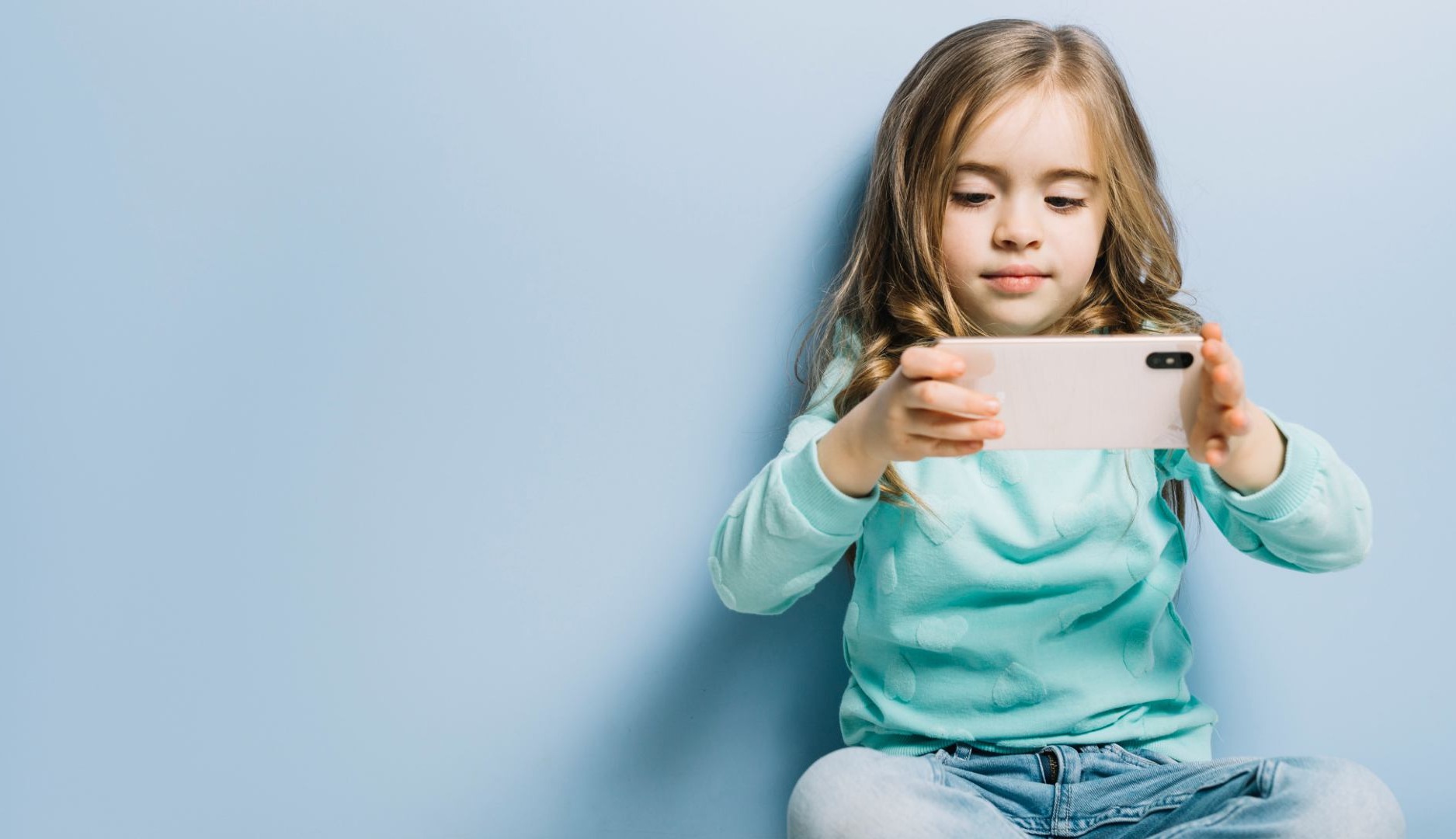 Niña mirando un teléfono móvil