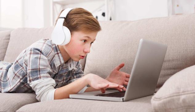 Niño mira un ordenador portátil