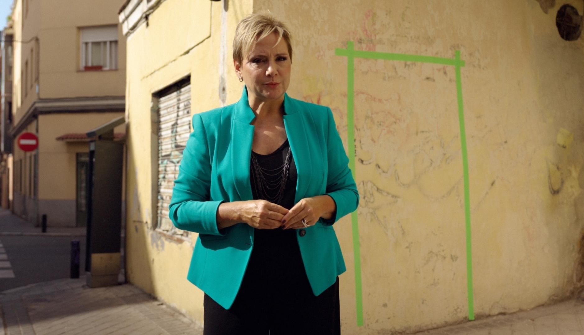 Gloria Serra frente a una pared con una puerta pintada