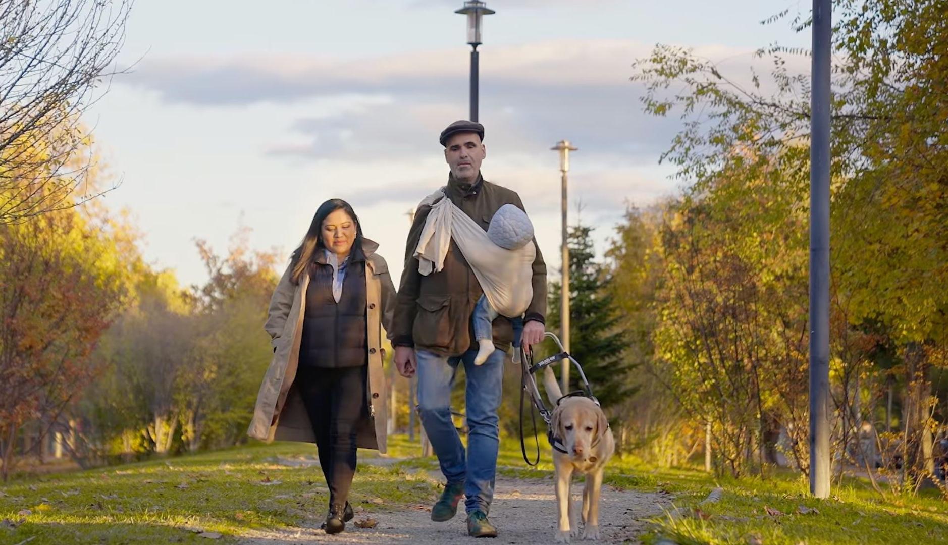 Un hombre ciego paseando con su perro y su familia