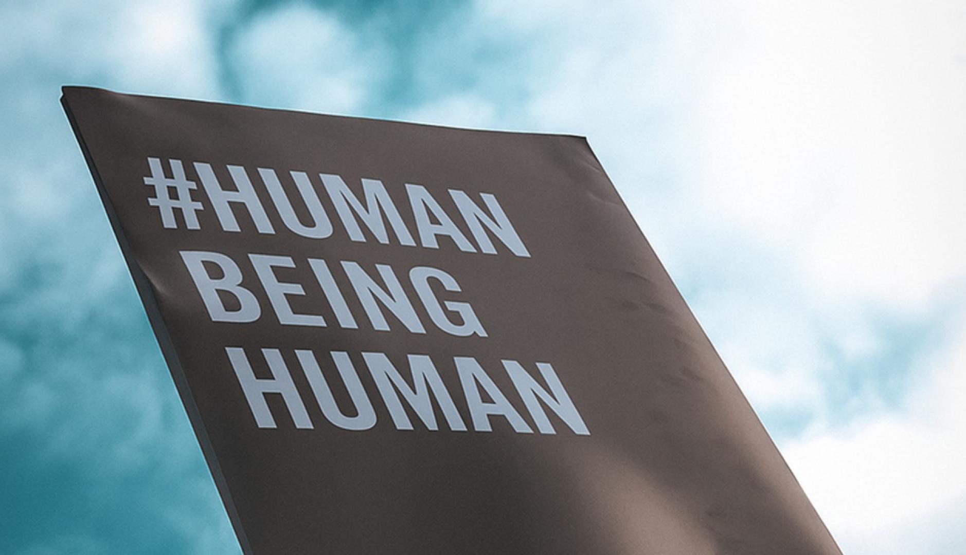 Un cartel en el que se lee Human Being Human