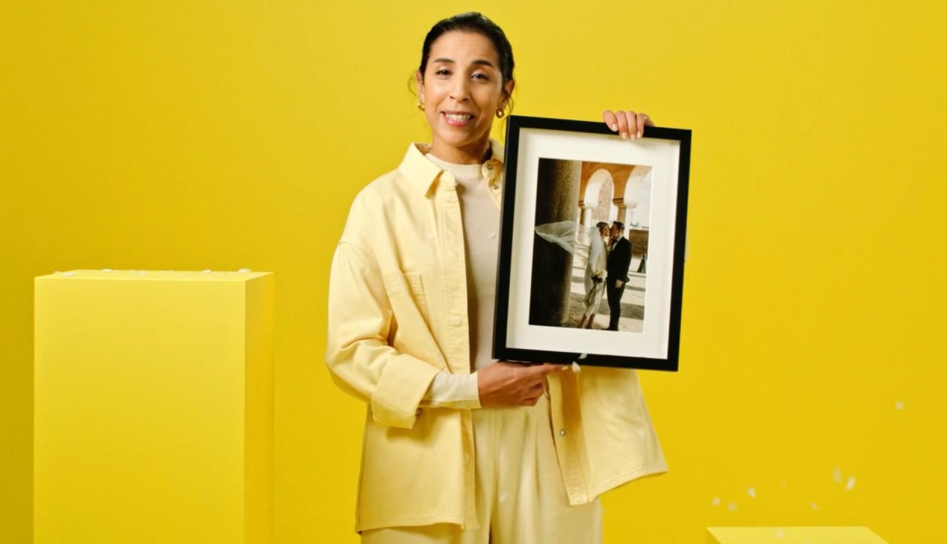 Una mujer enseña un cuadro con la foto de su boda