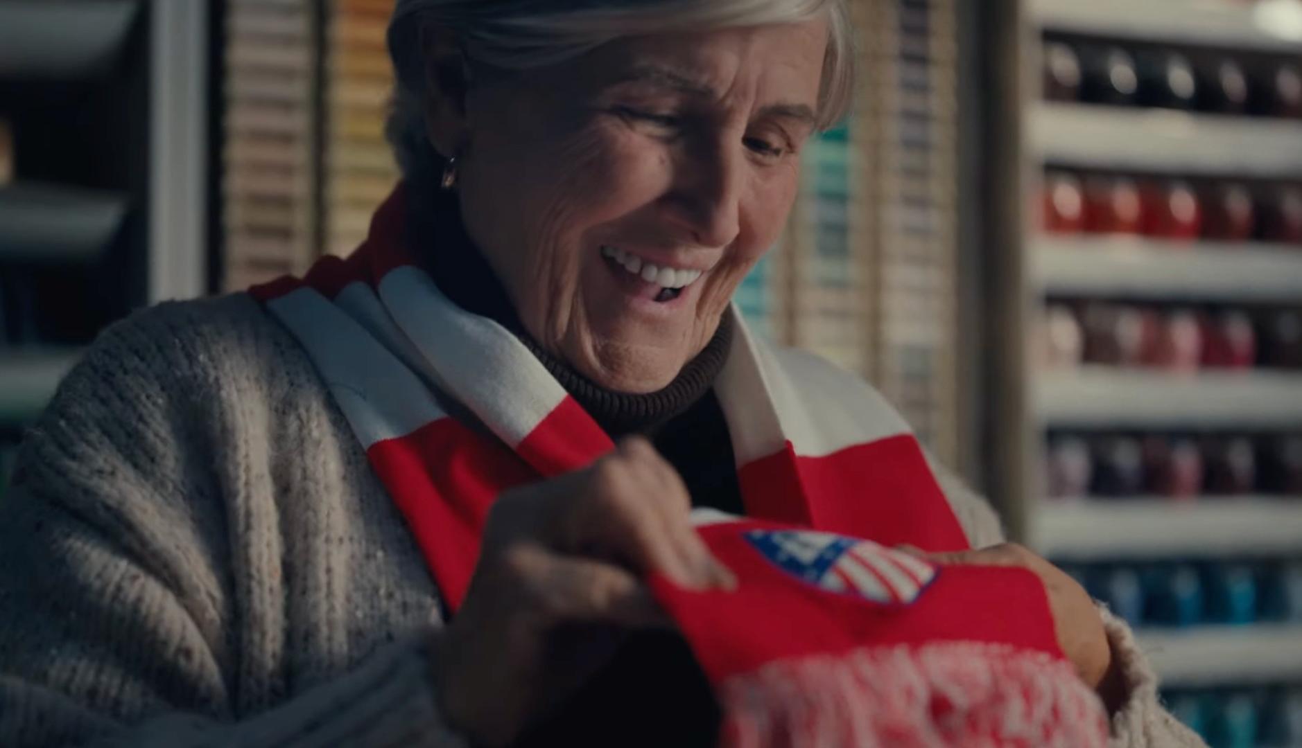 Mujer alegre al recibir una bufanda del Atlético de Madrid