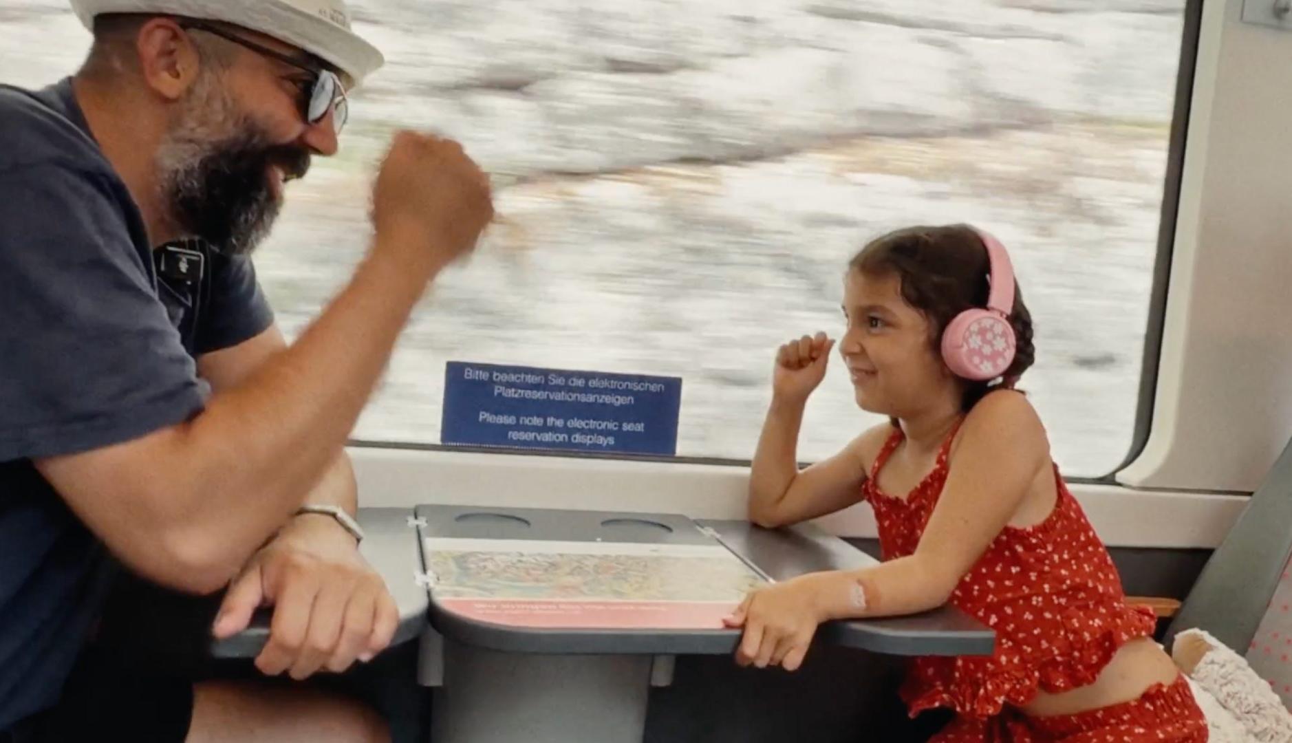 un padre y una hija juegan en un tren